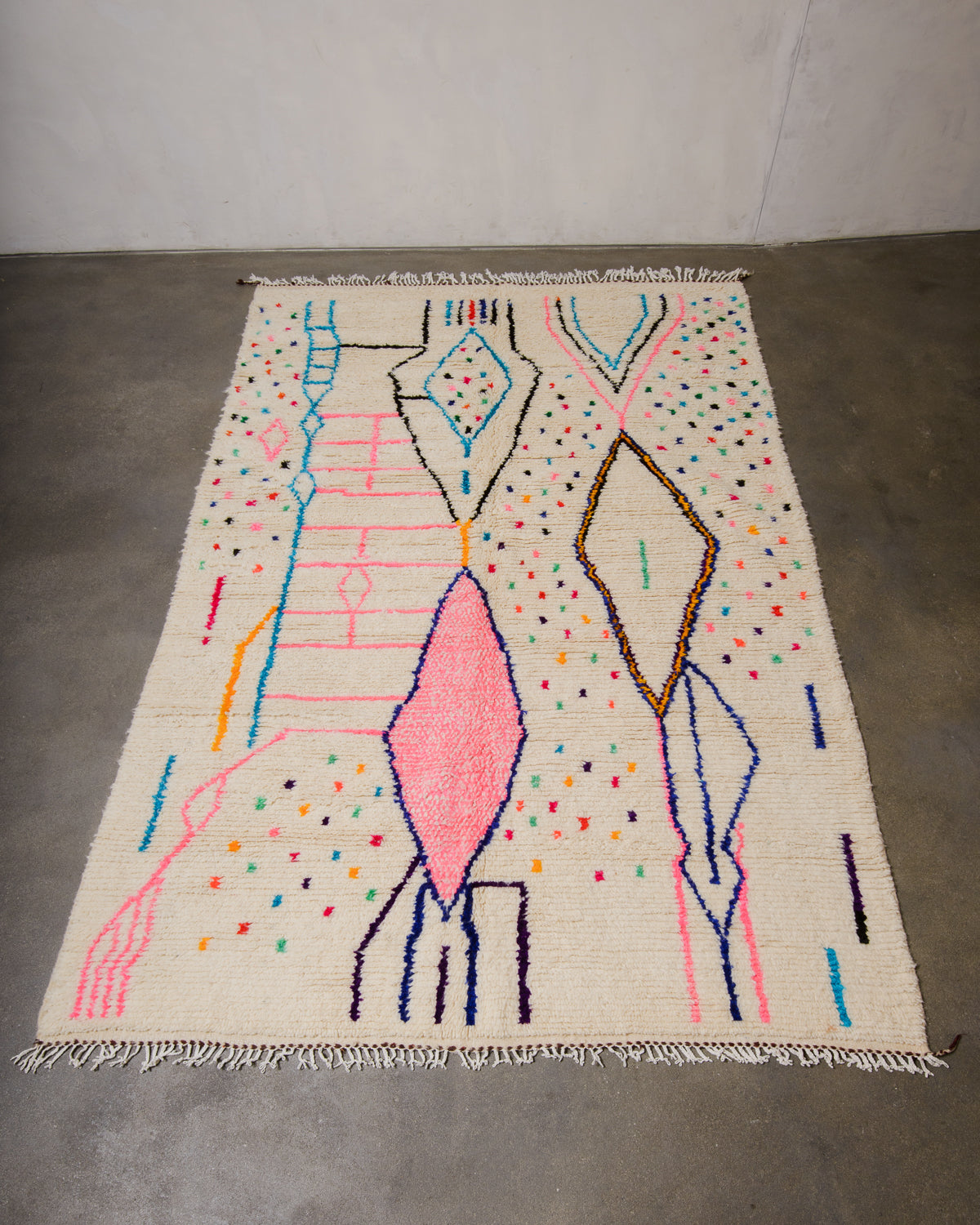 Berberlin Azilal rug made of fluffy wool and cotton, laying flat on a concrete floor.